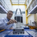 Un ingénieur examine un ressort spatial en titane imprimé en 3D