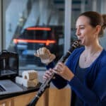 Une femme joue de la clarinette avec un doigt imprimé en 3D