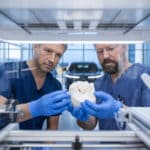 Un implant osseux 3D examiné par deux professionnels en laboratoire