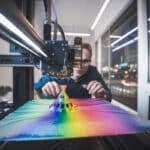 Un designer observe une impression 3D couleur en atelier contemporain